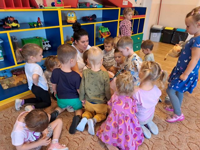 dzieci siedza na dywanie 