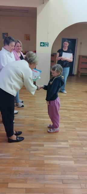 pani dyrektor gratuluje dziewczynce za udzial w konkursie