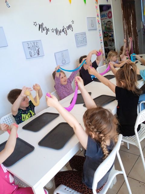 dzieci podnosza slaimy