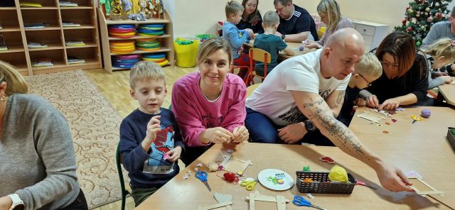 rodzice z dziecmi siedza przy stoliku