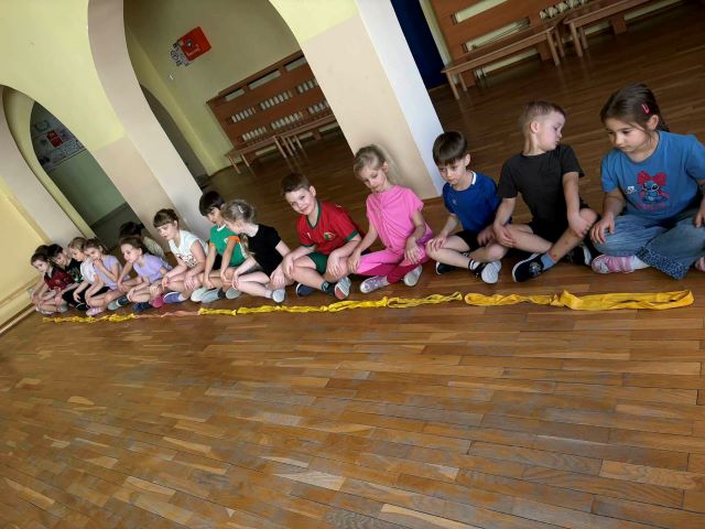 dzieci siedza z wyprostowanymi plecami